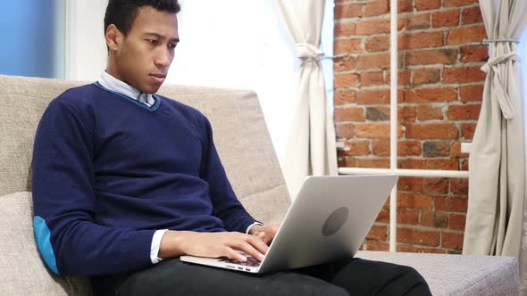 African Man in Tension and Headache Working on Laptop Home