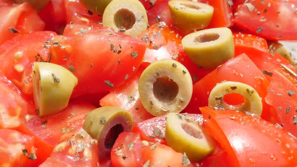 Olives and tomatoes appetizing salad with oil in a glass bowl slow tilt 4K 2160p 30fps UltraHD foota