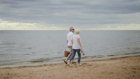 Wanderlust Mature Couple Enjoying Walk on Ocean Shoreline