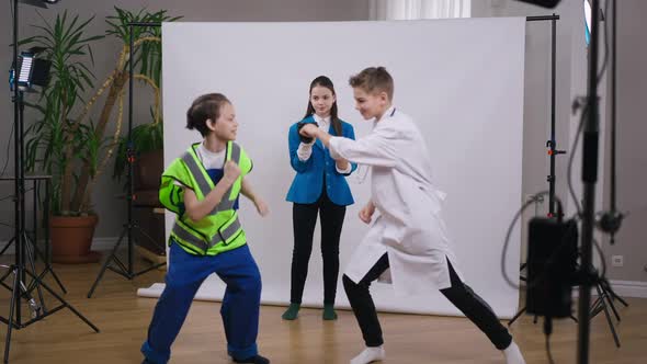 Wide Shot Portrait of Charming Beautiful Teenage Girl Standing with Camera As Blurred Caucasian Boys