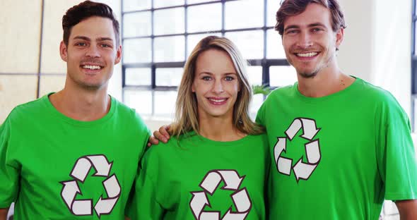 Volunteers wearing green ecologic t-shirt showing thumbs up