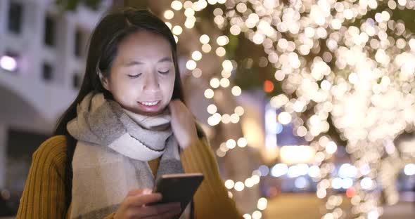 Asian Woman use of cellphone at night in the city