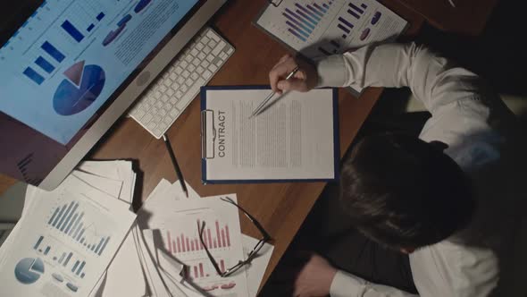 Businessman Checking Contract in Dark Office