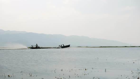 Silhouette Of People Sailing on Traditional Burmese Wooden Boat To Floating Village at Inle Lake