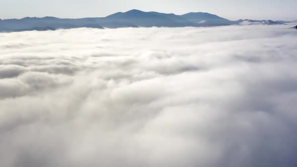 Aerial Flight Beyond Sky Over Morning Fluffy Clouds High in the Mountains