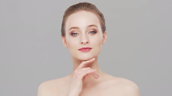 Studio portrait of young, beautiful and natural woman over grey background.