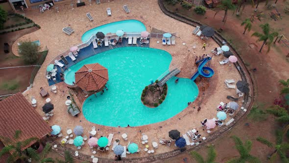 Topdown Orbiting over Swimming pool with Colorful sun Hats at Hotel resort, Minas Gerais. Brazil. Pe