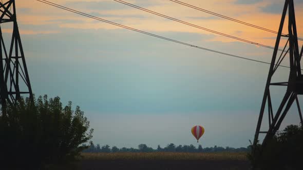 Breathtaking View of Colorful Hot Air Balloon Flying Over Field at Sunset