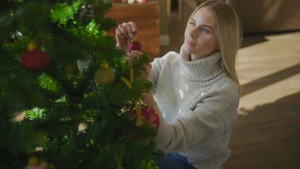 New Year, Christmas Woman Decorates a Christmas Tree