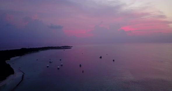 Wide drone travel shot of a white paradise beach and turquoise sea background in colourful 4K