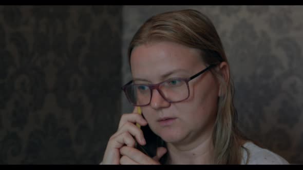 Woman with Wet Hair and Glasses Talks on Phone in Room