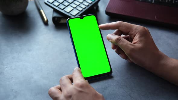 Rear View of Man Hand Using Smart Phone on Office Desk