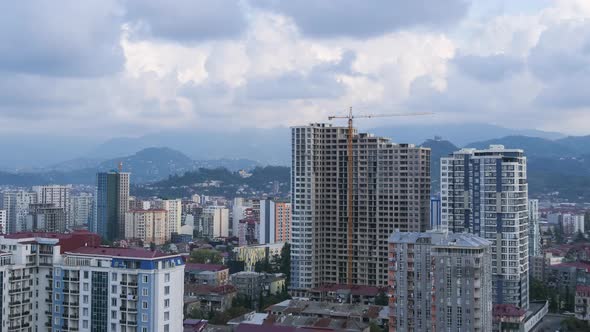 Building Construction. Timelapse. Tower Crane on a Construction Site Lifts a Load at High-rise