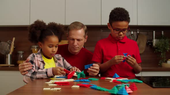 Grandfather and Multiracial Grandchildren Playing Developing Game at Home