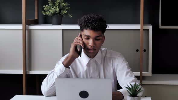 Young Adult Afro American Male Small Business Owner Working on Laptop in Store and Speaking To