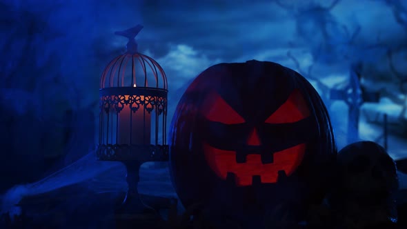 Scary laughing pumpkin and an old skull over the frightening gothic background.