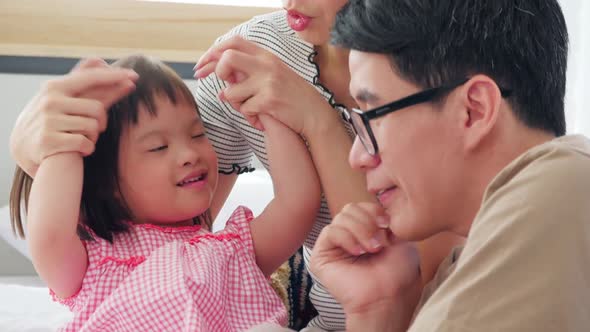 Happy family with mother, father and disabled daughter spending time together at home.