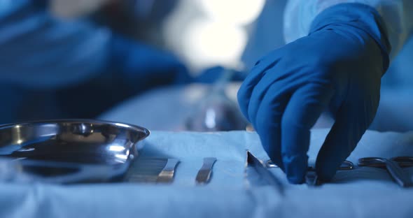 Surgery Instruments on Surgical Table with Medical Team and Patient on Blurred Background