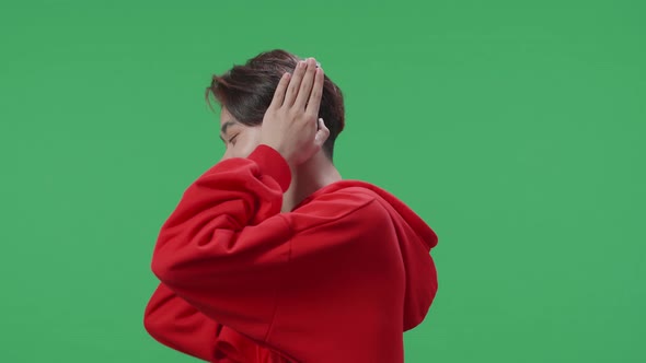 Side View Of Asian Transgender Listening To Music With Headphones And Dancing In The Green Screen