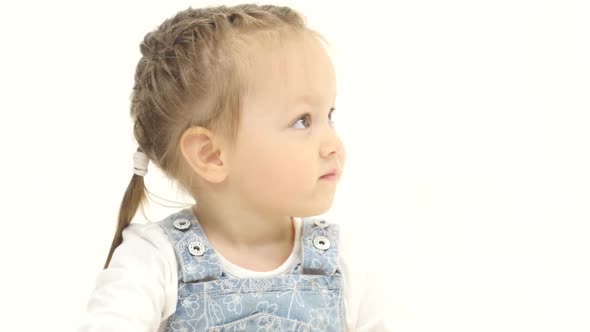 Baby Is Sitting on the Floor Asking To Give Her Candy. White Background