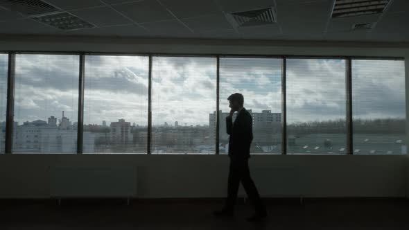 Contour Lighting Businessman Walks in Front of a Panoramic Window Waiting Process Morning in a