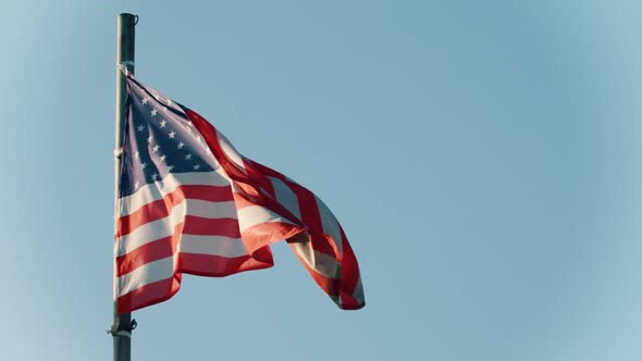 Flag of USA Blowing in the Wind on the Background of Clear Blue Sky