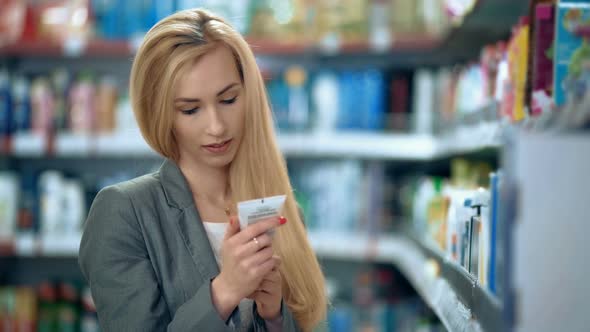 Beautiful Woman Choosing Personal Care Product in Supermarket