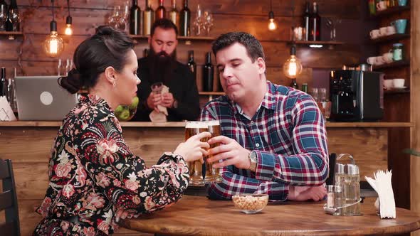 Beautiful Caucasian Couple Eating Peanuts and Drinking Beer