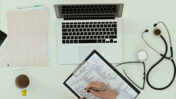 Female Doctor Filling in Form and Making Consultation By Skype