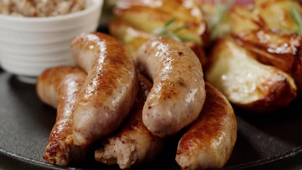 Bowl with Sauce and Smoked Sausages with Fried Potatoes Rotating Closeup