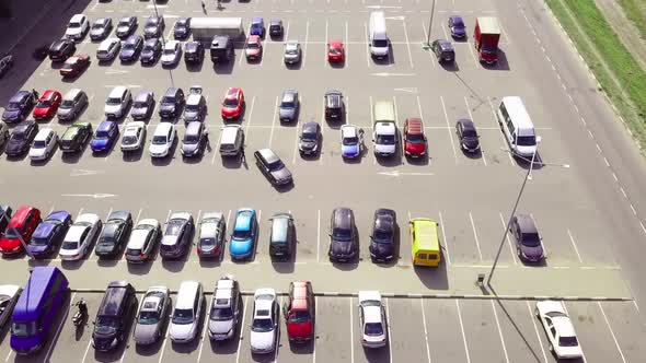 A bird's-eye view of parked cars in the parking lot near the shopping center.
