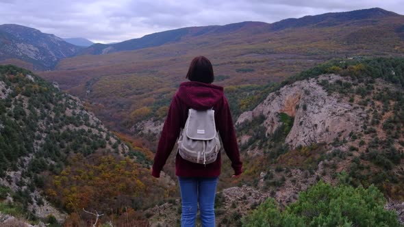 Hipster Woman with Backpack Walking at the Autumn Mountains Nature