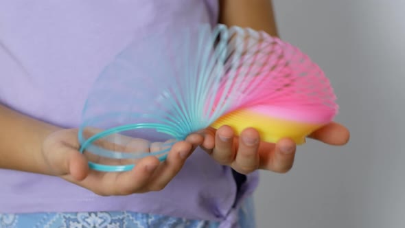 Slinky Rainbow Toy. A rainbow spiral in a child's hands.