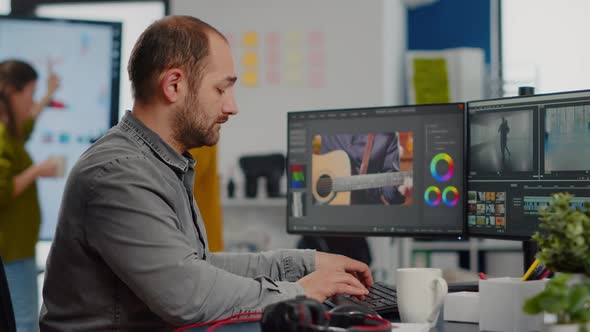 Videographer Looking at Camera Smiling Working in Creative Startup Workplace