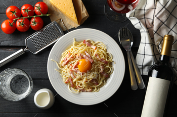 Composition with plate of tasty pasta and ingredients for cooking on wooden background / Photodune, Misc