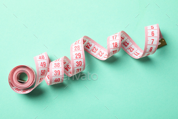Measuring tape on mint background. Weight loss concept / Photodune, Misc