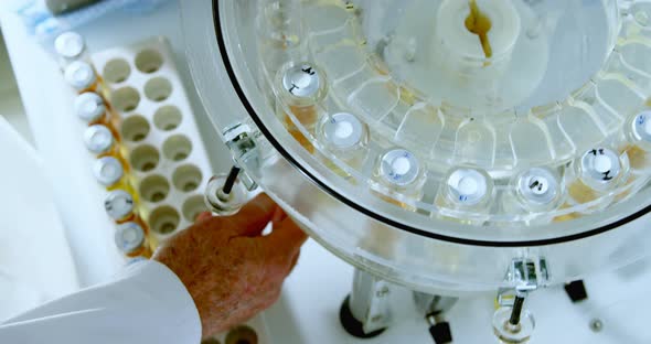 Male scientist removing medical vials from centrifuge 4k