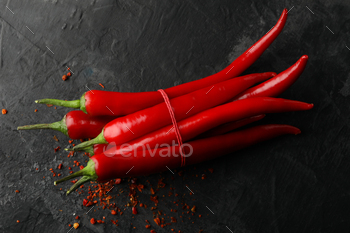 Tasty chilli peppers on black cement background / Photodune, Misc