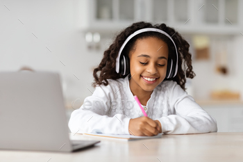 Pretty african american girl enjoying online lesson, kitchen interior / Photodune, Misc