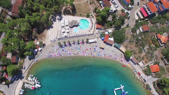 View from above of sandy beach with palms and towels, Solta island, Croatia