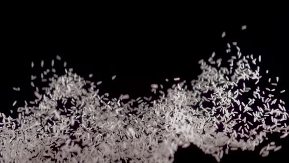White Rice Flies Up on a Black Background. Slow Motion Video. Food Video White Rice