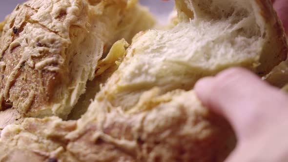 Close Up on Hands Tearing Piece of Fresh Baked Steamy Bread