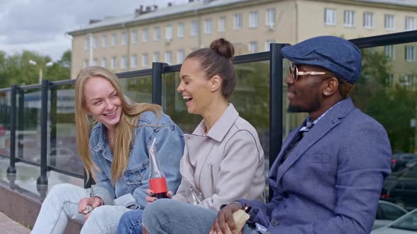 Laughing friends sitting on the street