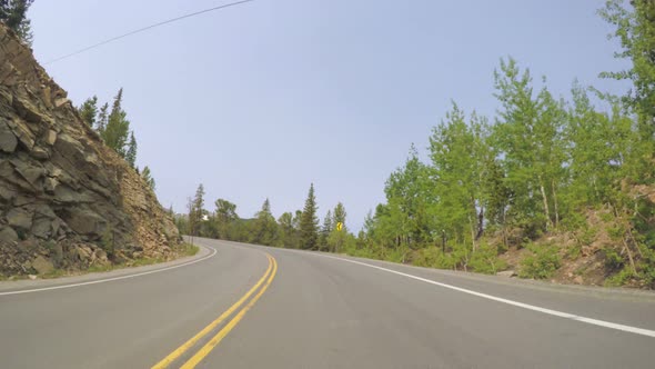 Car driving through alpine forest on Mount Evans-POV point of view