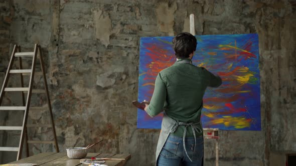 Male Artist Approaches the Painting and Makes Strokes with a Brush / Videohive