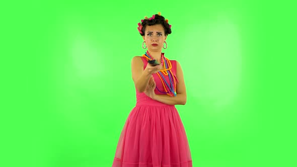 Woman with TV Remote in Her Hand, Switching on TV. Green Screen