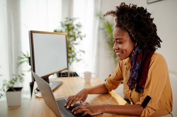 Beautiful girl is using laptop and looking and screen, searching for new ideas, typing and smiling. / Photodune, Misc
