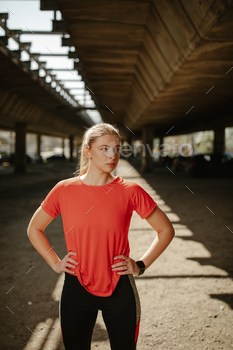 橋の下に立ってトレーニング セッションの後に休むスポーツウェアの美しいフィットネスの女の子。 / Photodune, Misc