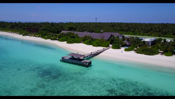 Aerial flying over travel of tropical tourist beach trip by blue green sea and clean sandy backgroun