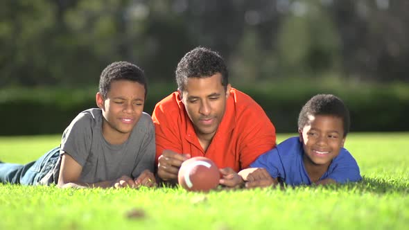 Group portrait of a father and his sons with a football.